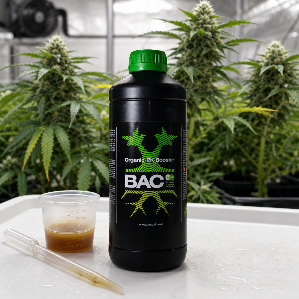 Botella negra de B.A.C Organic PK Booster con tapón verde, junto a un vaso medidor y una pipeta, con plantas de cannabis al fondo.