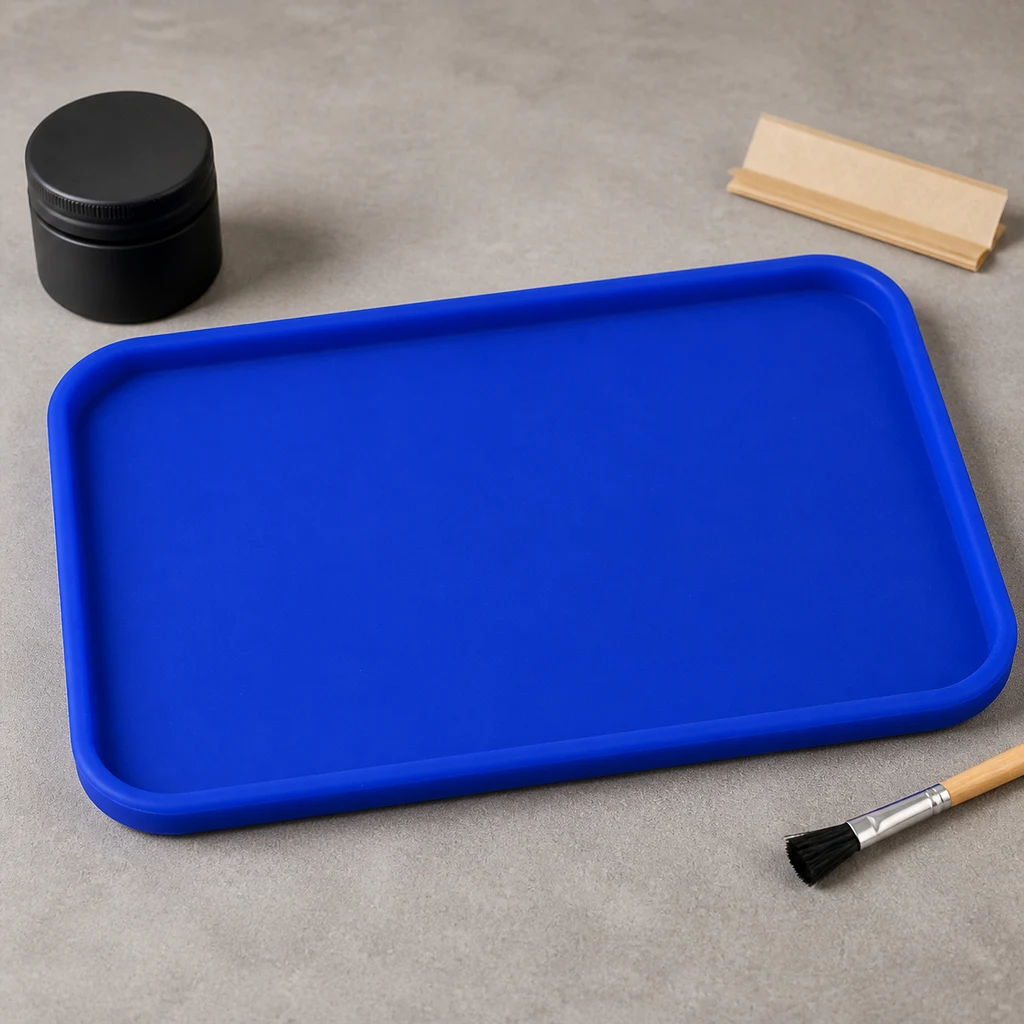 Bandeja de liar azul rectangular con esquinas redondeadas y borde elevado, sobre una mesa con grinder, papel y pincel alrededor.