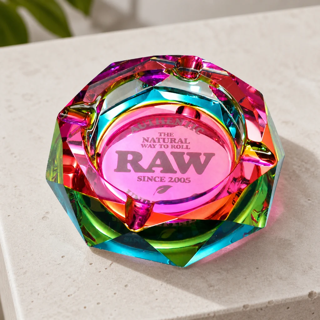 Recipiente RAW Rainbow Crystal de bordes facetados multicolores, con muescas en el borde y logotipo central, sobre una superficie clara.