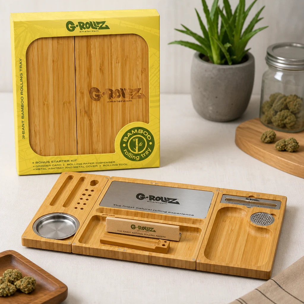Bandeja de bambú G-Rollz desplegada, con compartimentos, placa metálica y accesorios, delante de su caja amarilla.