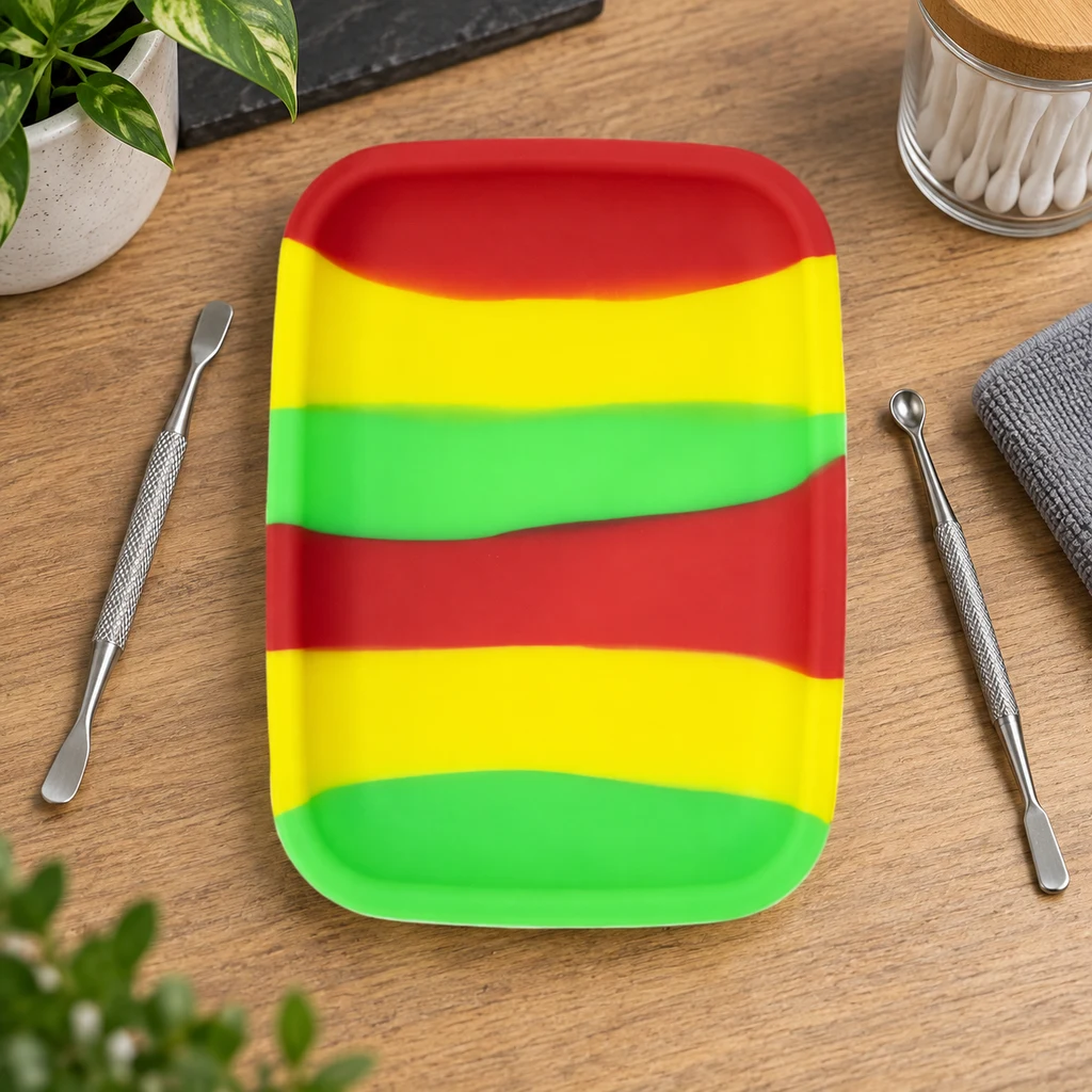 Bandeja rectangular con bordes elevados y franjas rojas, amarillas y verdes, sobre una mesa con utensilios metálicos a los lados.