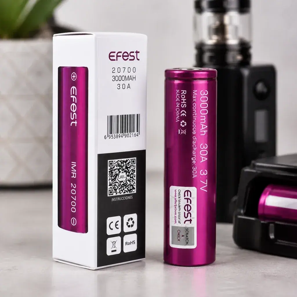 Batería Efest magenta junto a su caja, con indicaciones 20700, 3000 mAh, 30 A y 3,7 V; al fondo aparecen un vapeador y un cargador.