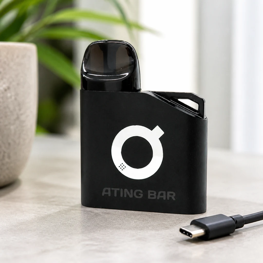 Batería Ating EVO-1 negra con boquilla oscura y logotipo blanco, sobre una mesa junto a un cable USB-C, en una escena generada.