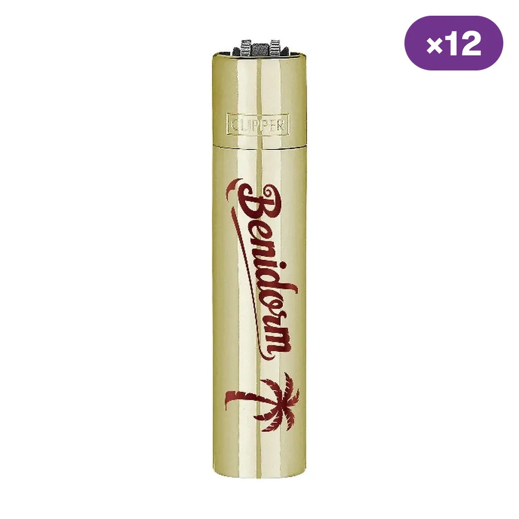 Encendedor Clipper dorado con inscripción roja «Benidorm» y una palmera, sobre fondo blanco con indicador ×12.