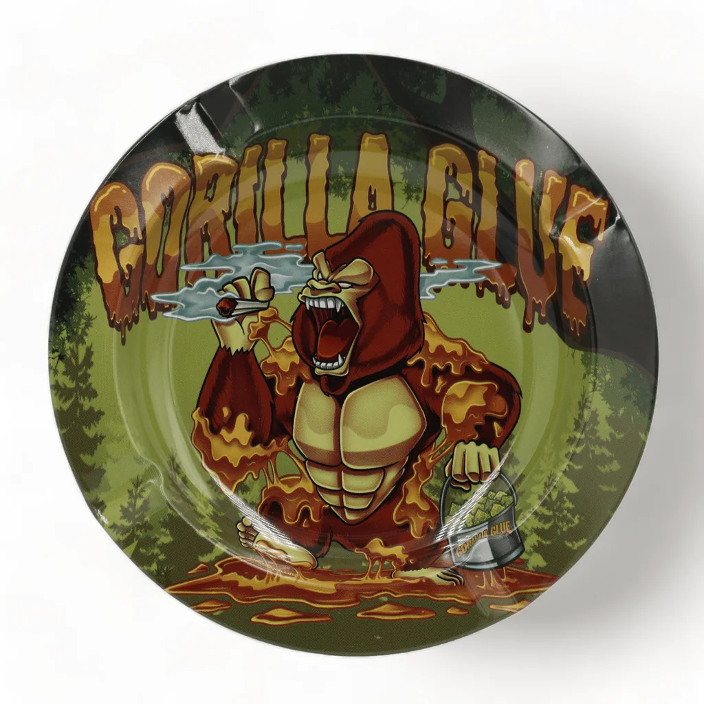 Cenicero redondo con un gorila ilustrado sosteniendo un cigarro y un cubo, fondo de bosque y texto «GORILLA GLUE».