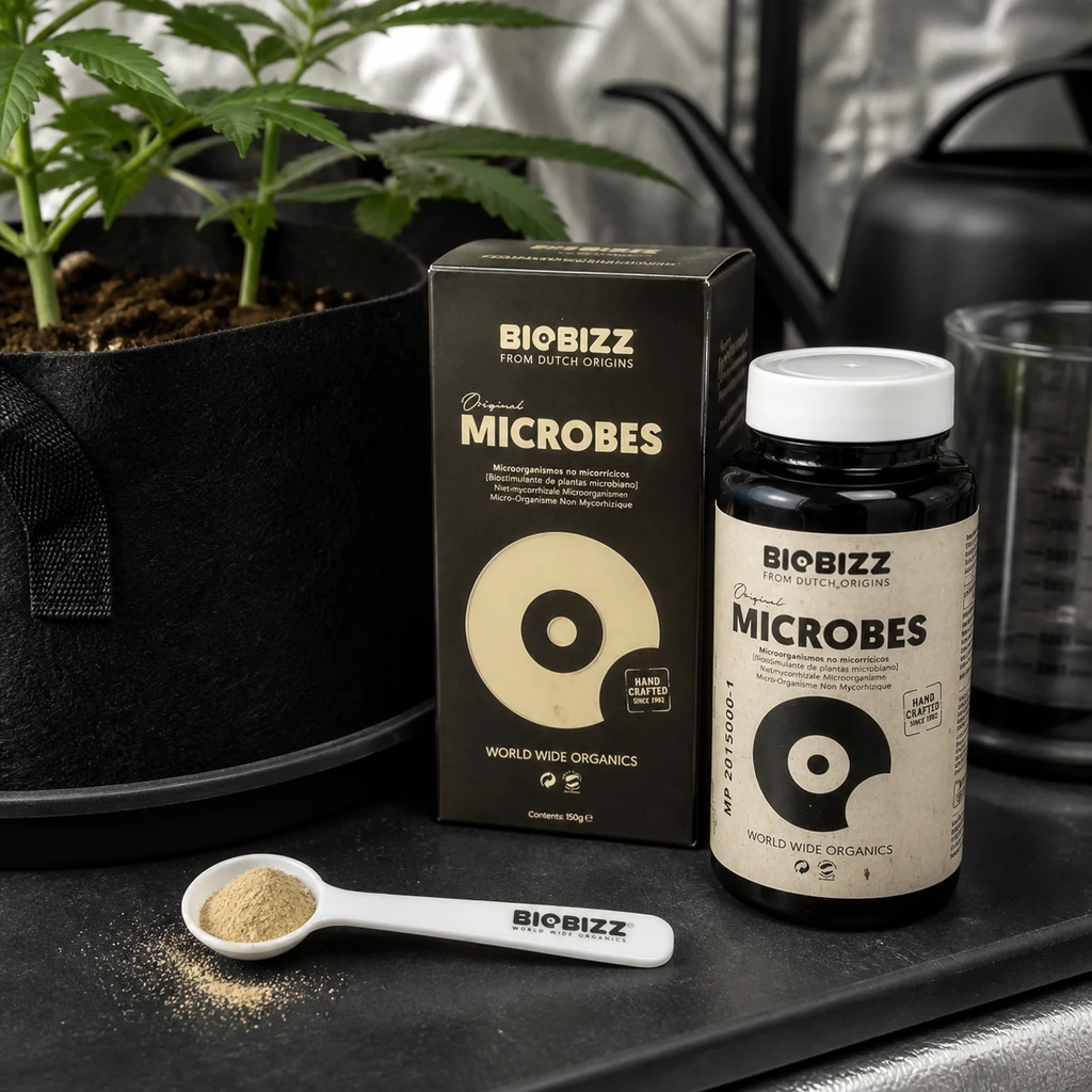 Escena generada de BioBizz Microbes con bote, caja y cuchara con polvo junto a una maceta con plantas, una regadera y un vaso graduado.
