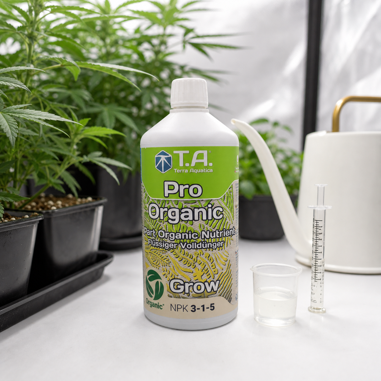 Botella Pro Organic Grow de Terra Aquatica con etiqueta NPK 3-1-5, junto a un vaso, una jeringa y una regadera, entre plantas.