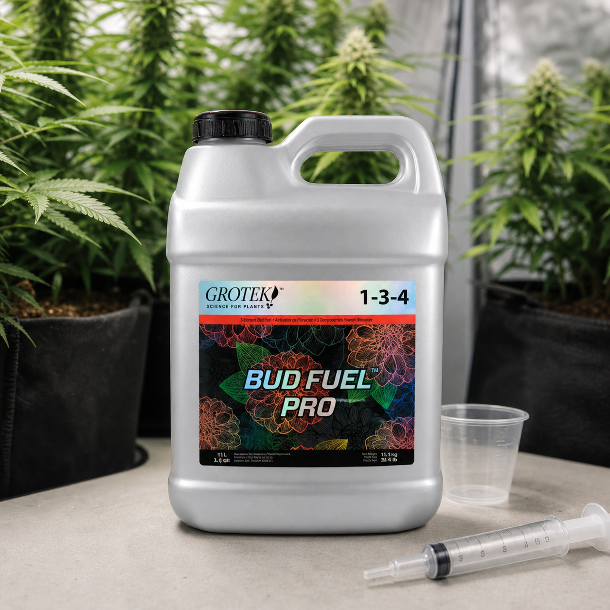 Garrafa de Grotek Bud Fuel Pro con etiqueta 1-3-4, junto a un vaso y una jeringa dosificadora, con plantas al fondo. Garrafa de Grotek Bud Fuel Pro con etiqueta 1-3-4, junto a un vaso y una jeringa dosificadora, con plantas al fondo.