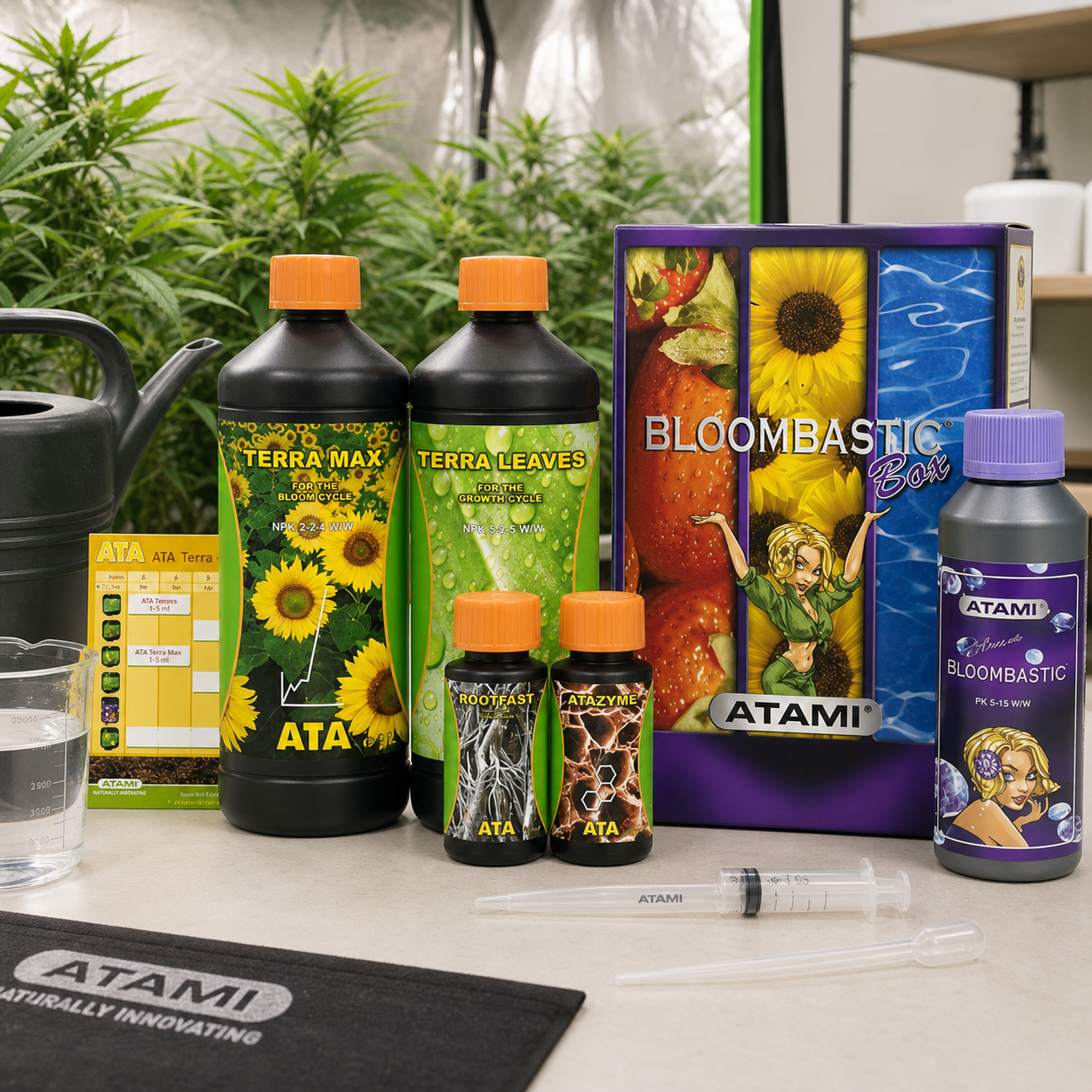 Caja Bloombastic de Atami junto a botes Terra Max, Terra Leaves, Rootfast, Atazyme y Bloombastic, con plantas al fondo. Caja Bloombastic de Atami junto a botes Terra Max, Terra Leaves, Rootfast, Atazyme y Bloombastic, con plantas al fondo.