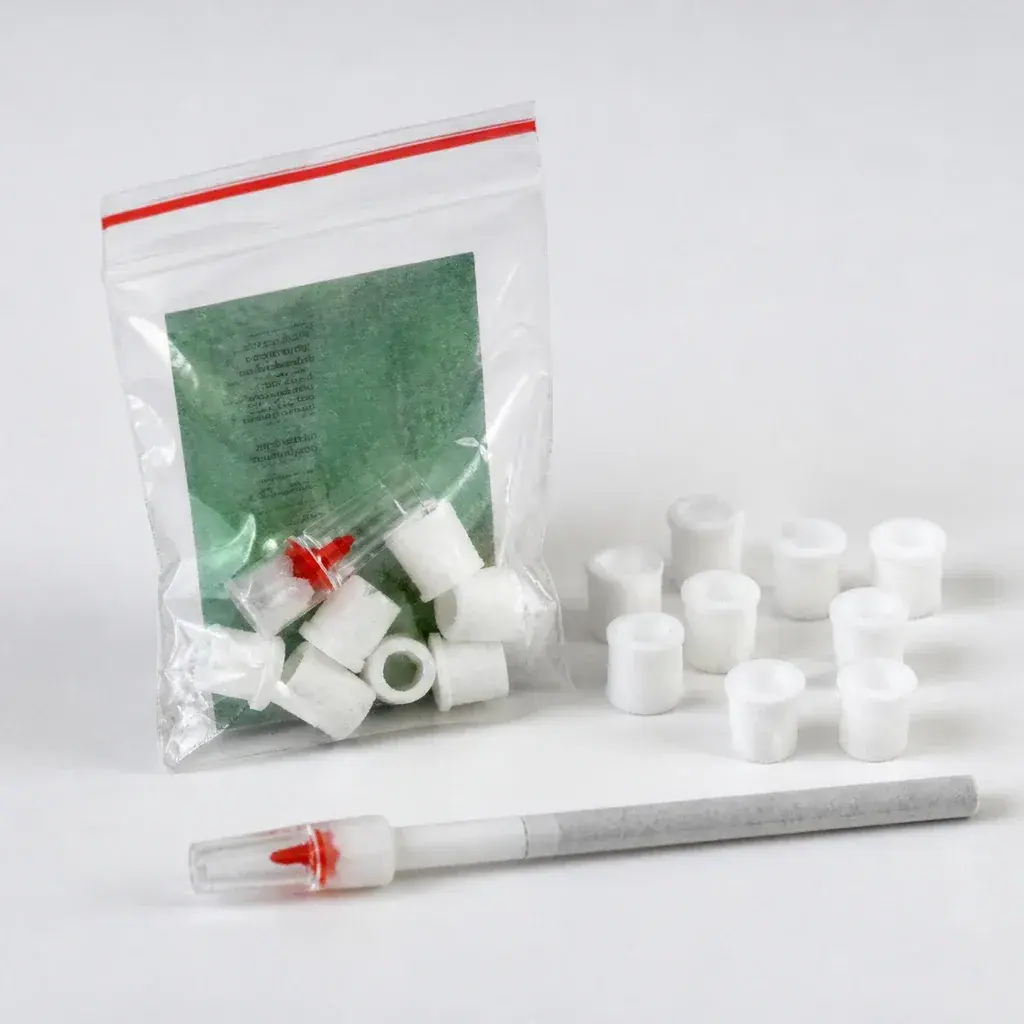 Fundas reductoras blancas TarGard Mini junto a una bolsa transparente y un cigarrillo con boquilla transparente de pieza roja.