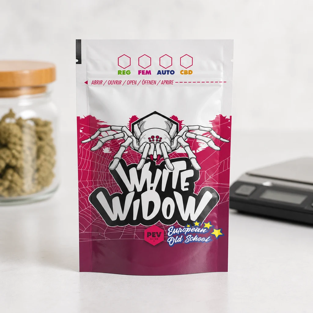 Bolsa White Widow blanca y fucsia, decorada con una araña y telarañas, sobre una mesa con un tarro de cogollos y una báscula al fondo.