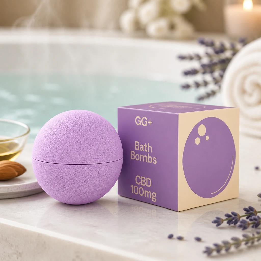 Bomba de baño esférica violeta junto a una caja GG+ rotulada «CBD 100mg», con lavanda, una toalla y una bañera al fondo.
