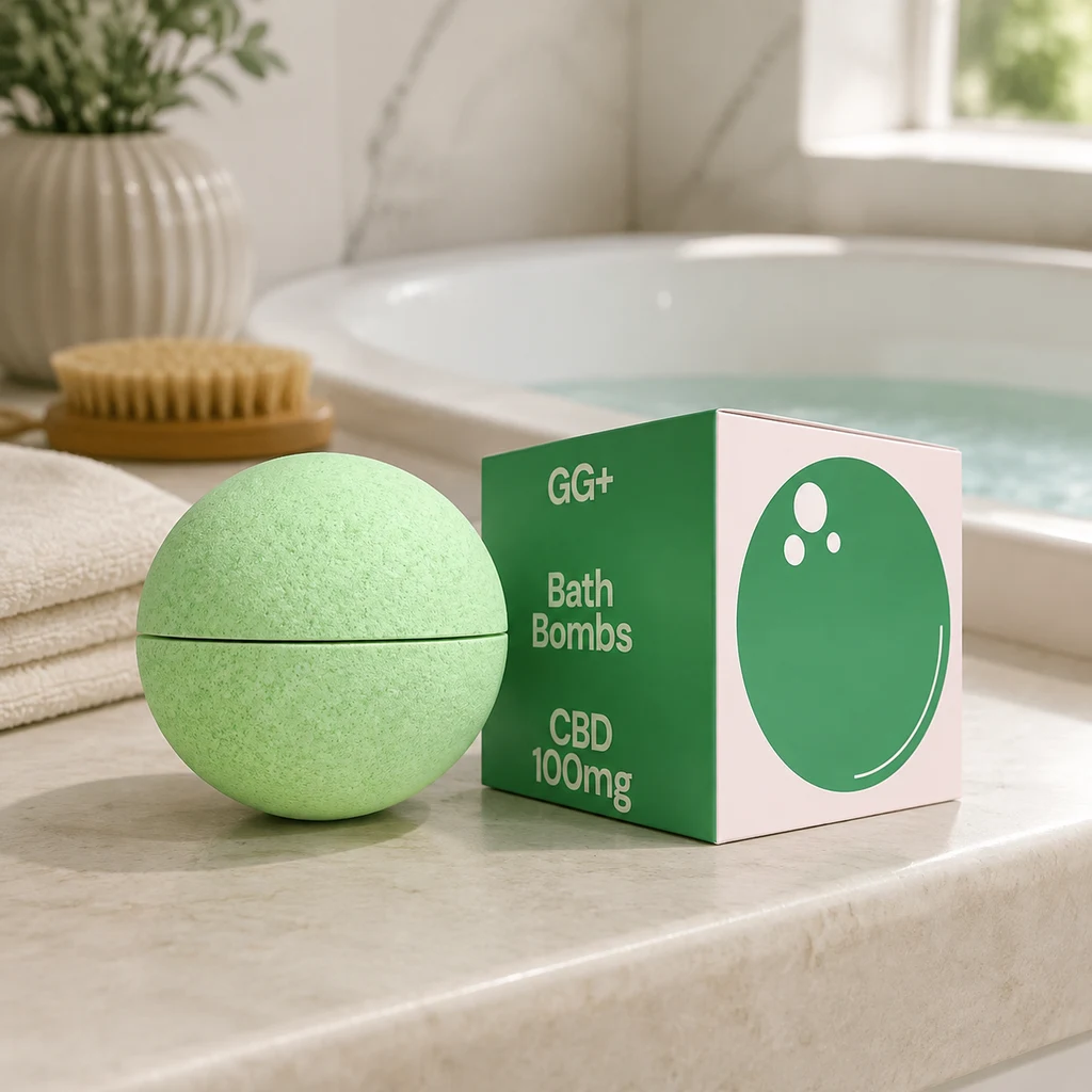 Bomba de baño verde junto a una caja GG+ con la inscripción CBD 100 mg, sobre el borde de una bañera con agua.