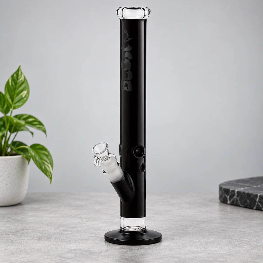 Bong negro de tubo recto con borde transparente, base circular y cazoleta lateral de vidrio, sobre una superficie gris.