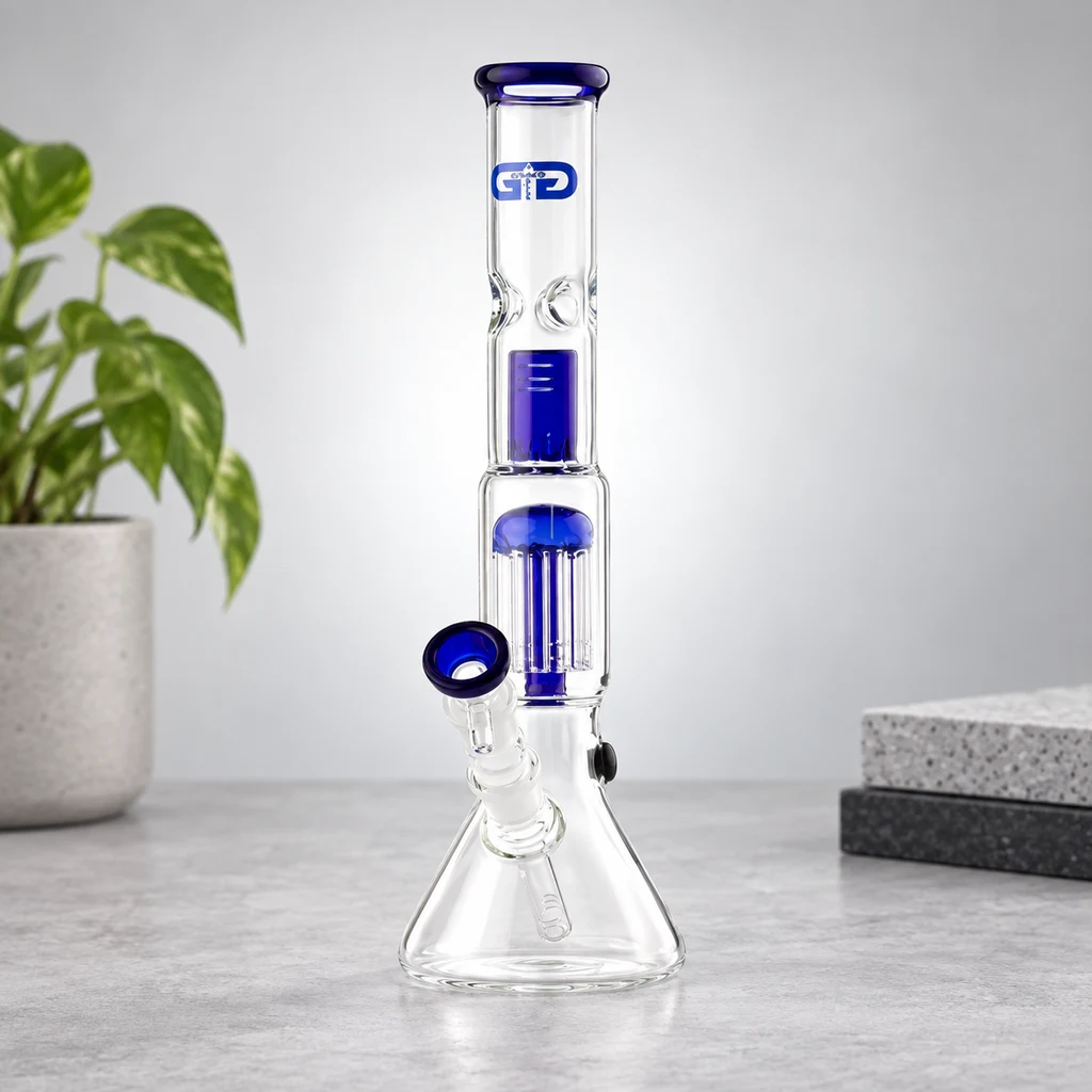 Bong de cristal OG Blue con base cónica, percolador y detalles azules en la boquilla y la cazoleta, sobre una mesa gris.