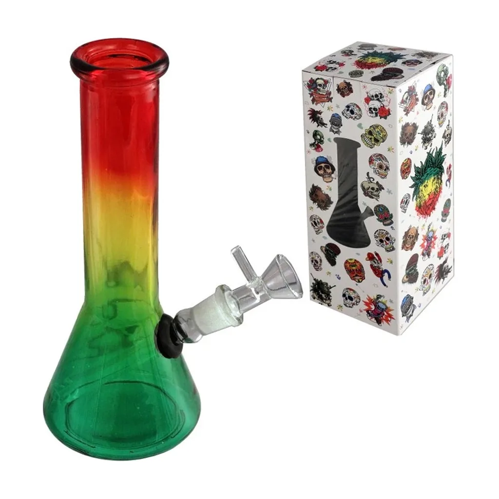 Bong de cristal Rasta con base verde, cuello amarillo y rojo y cazoleta lateral transparente, junto a una caja decorada con calaveras.