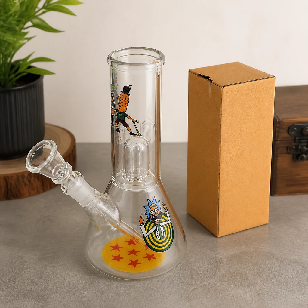 Bong de cristal transparente con base ancha, cazoleta lateral y dibujos de Rick and Morty, junto a una caja marrón sobre una mesa.
