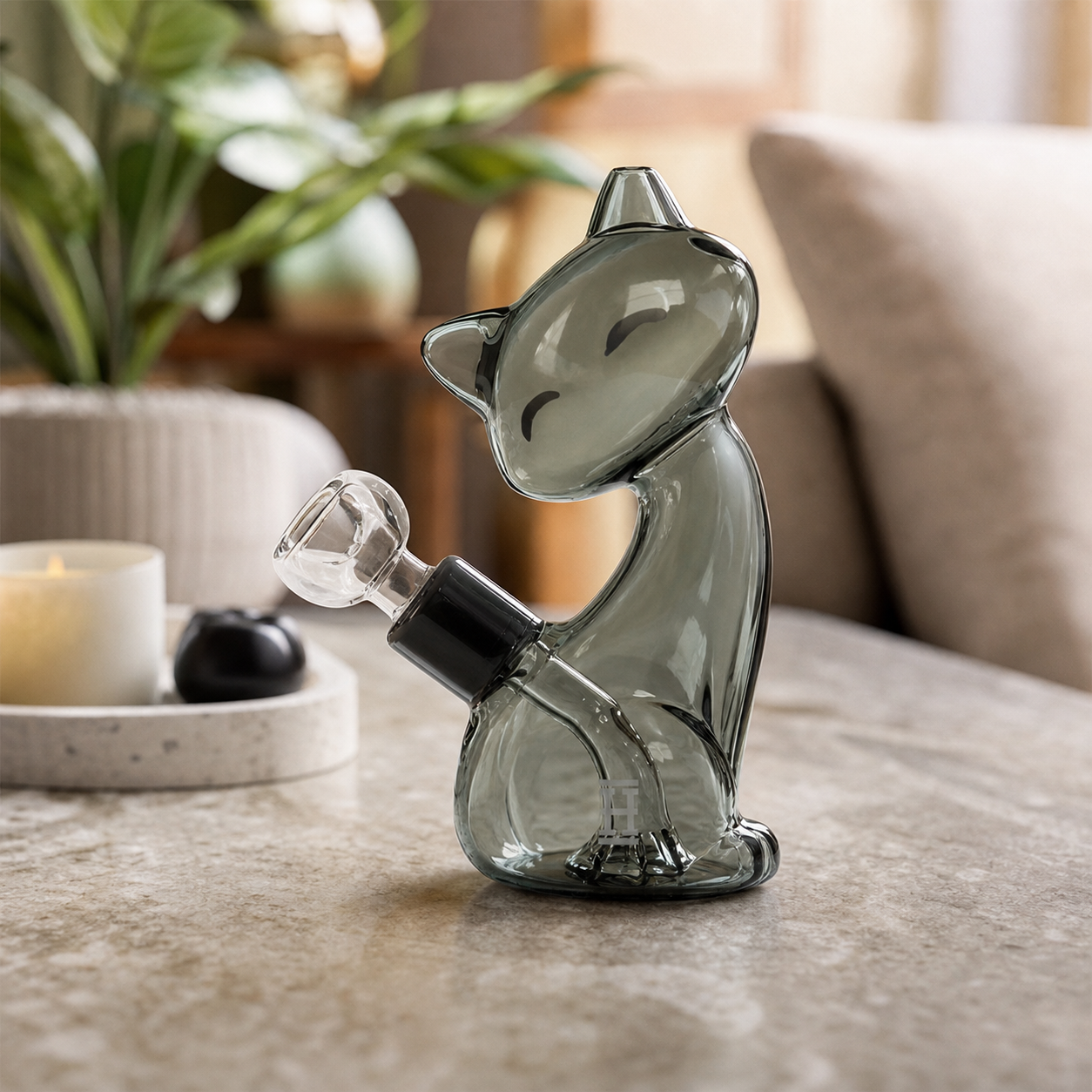 Bong Hemper Alleycat de vidrio gris translúcido con forma de gato sentado y cazoleta transparente lateral sobre una mesa.
