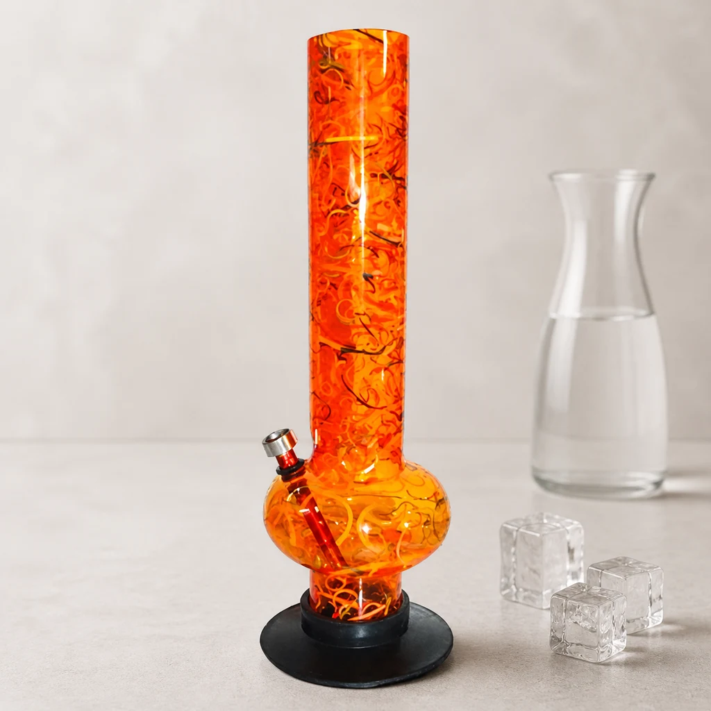Bong naranja translúcido con diseño de espirales, tubo recto, cámara abombada y base negra, junto a tres cubitos y una jarra de agua.