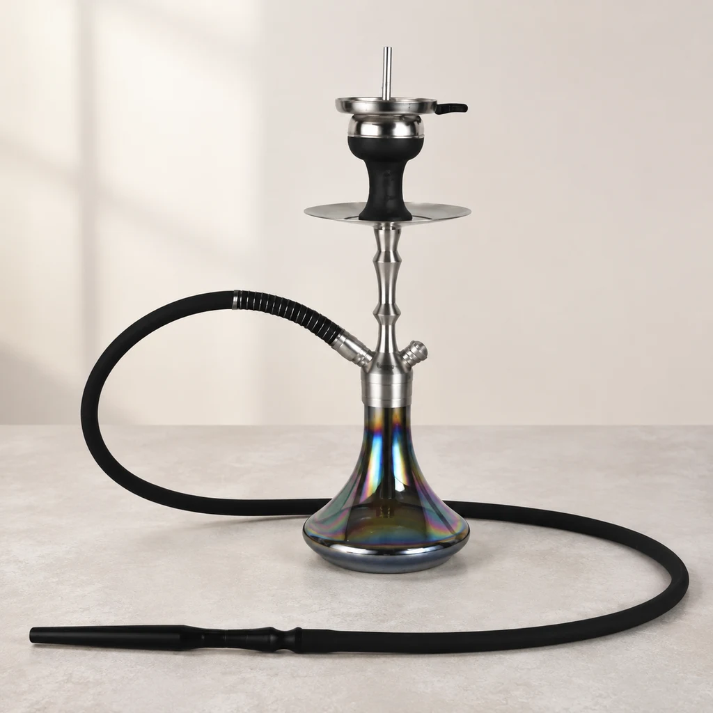 Cachimba Aladin MVP360 con mástil plateado, base de reflejos irisados y manguera negra extendida sobre una mesa.