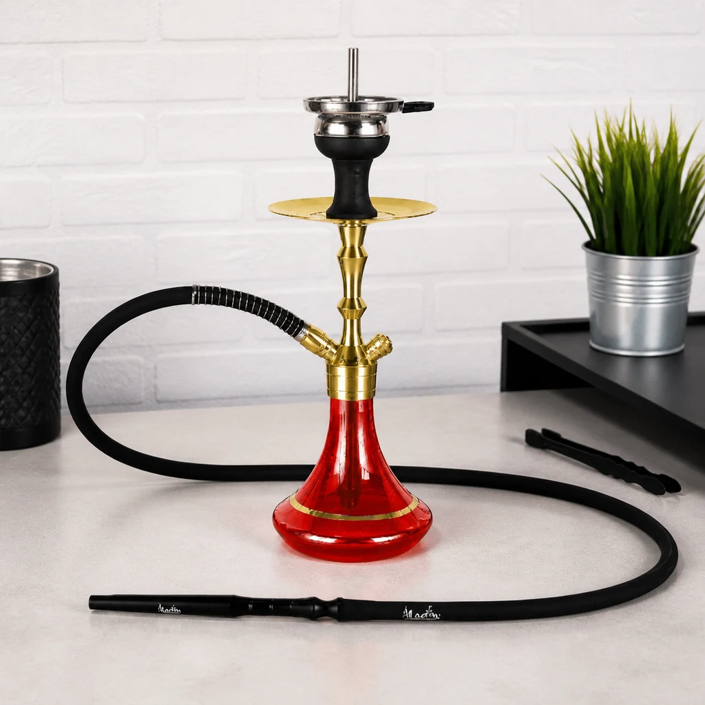 Cachimba Aladin MVP360 GOLD Roja con base roja, cuerpo dorado y manguera negra extendida sobre una mesa junto a unas pinzas.