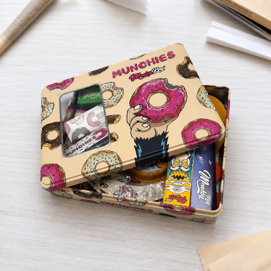 Escena generada de caja Monkey King Munchies entreabierta, decorada con rosquillas y una mano ilustrada, con accesorios de liar dentro.