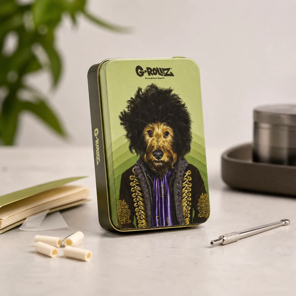 Cajita verde G-Rollz con un perro de peinado voluminoso y chaqueta ornamentada, junto a papel de liar, filtros y un utensilio metálico.