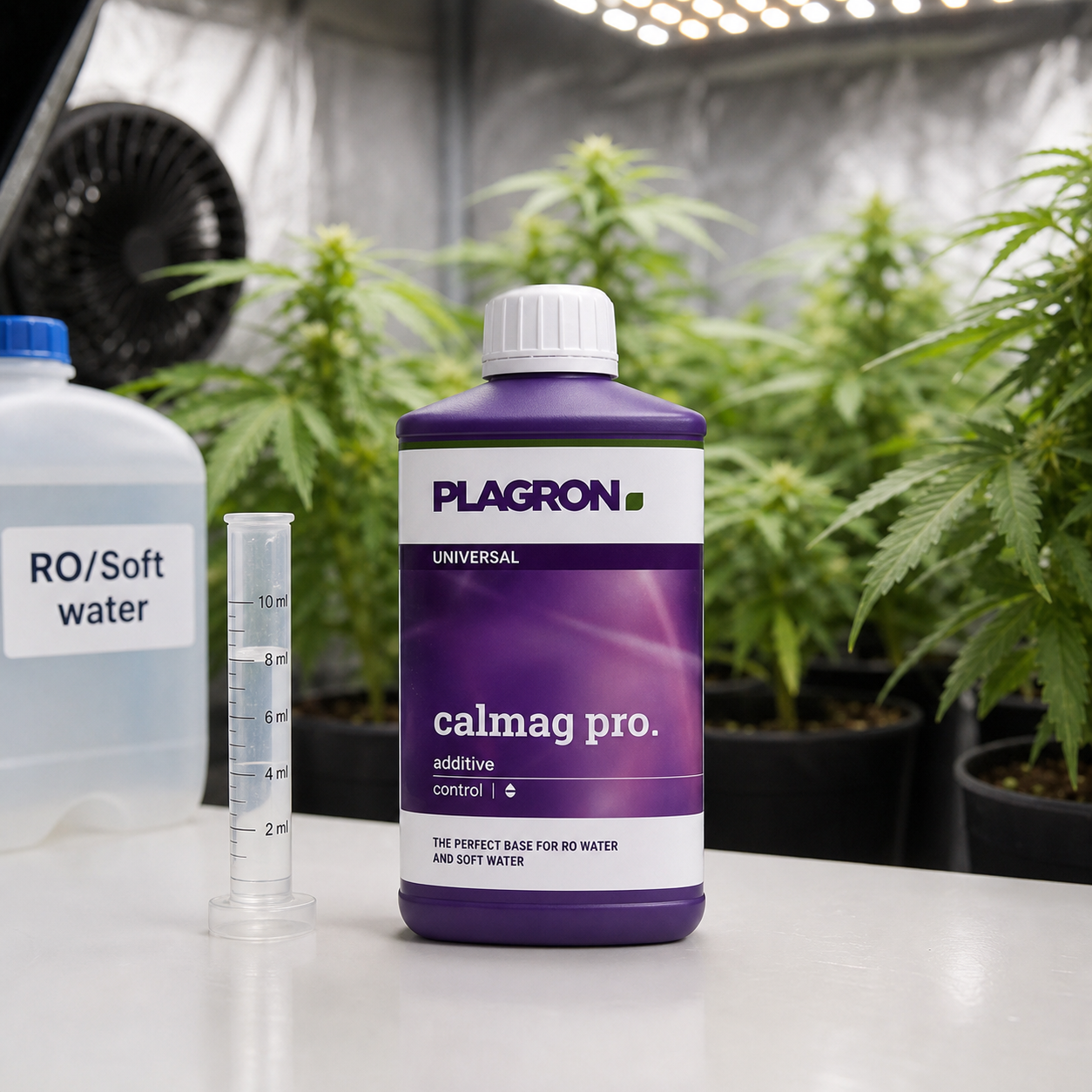 Bote morado de CalMag Pro de Plagron junto a una probeta y una garrafa rotulada RO/Soft water, con plantas al fondo. Bote morado de CalMag Pro de Plagron junto a una probeta y una garrafa rotulada RO/Soft water, con plantas al fondo.