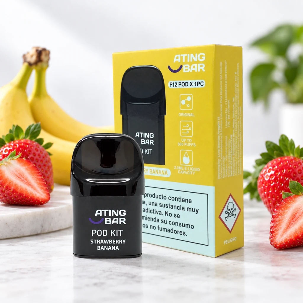 Pod negro Ating Strawberry Banana delante de su caja amarilla, rodeado de fresas y plátanos sobre una superficie clara.