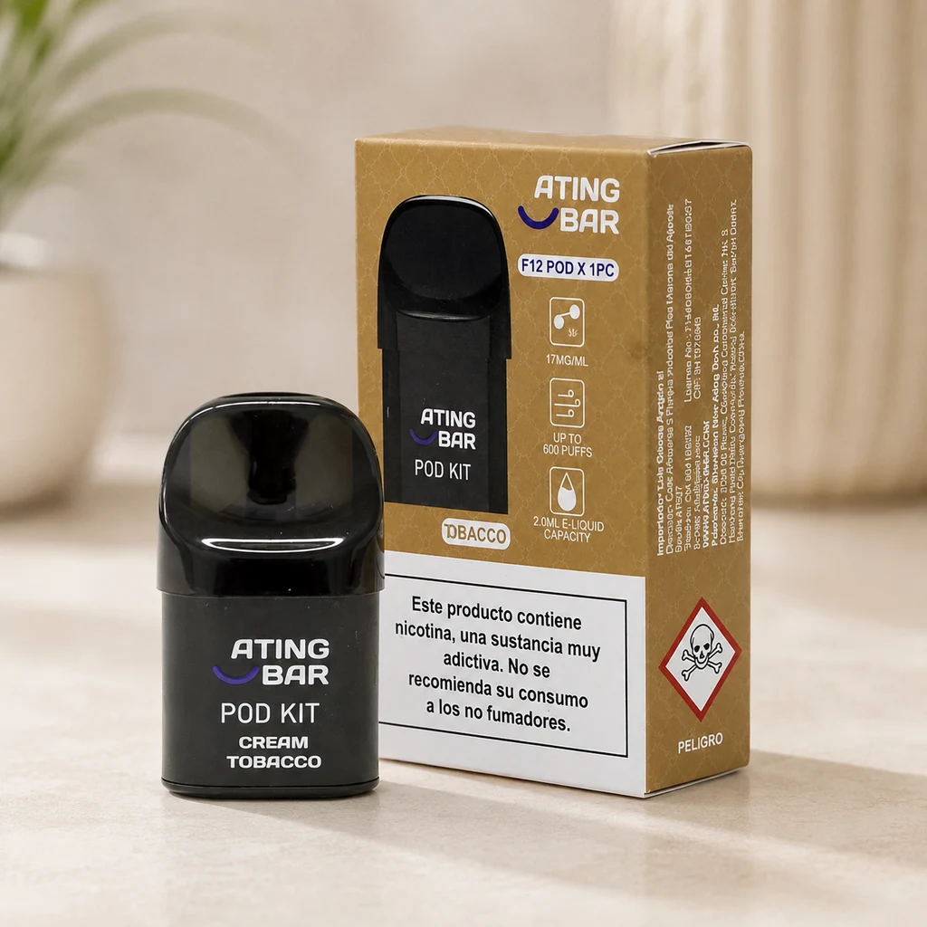 Pod negro Ating Bar con texto Cream Tobacco junto a su caja dorada, con advertencia sobre nicotina y pictograma de peligro.