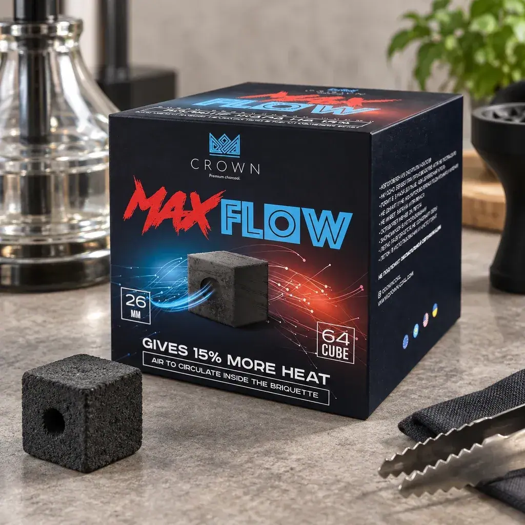 Caja negra de carbón Crown Max Flow junto a un cubo con orificio central, unas pinzas y una cachimba parcialmente visible al fondo. Caja negra de carbón Crown Max Flow junto a un cubo con orificio central, unas pinzas y una cachimba parcialmente visible al fondo.