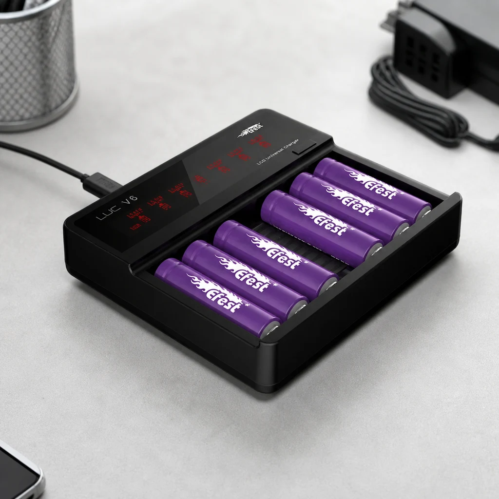 Cargador negro Efest LUC V6 con varias baterías moradas colocadas, pantalla con indicadores rojos y cable conectado sobre una mesa.