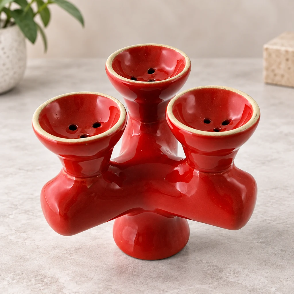 Cazoleta triple de cerámica roja brillante, con bordes crema y orificios en los cuencos, sobre una superficie clara.