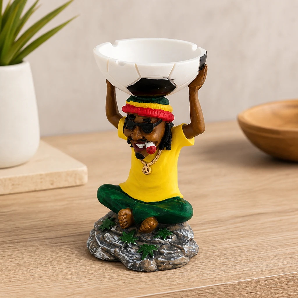 Figura con gorro tricolor, gafas oscuras y camiseta amarilla que sostiene sobre la cabeza una bandeja con diseño de balón de fútbol.