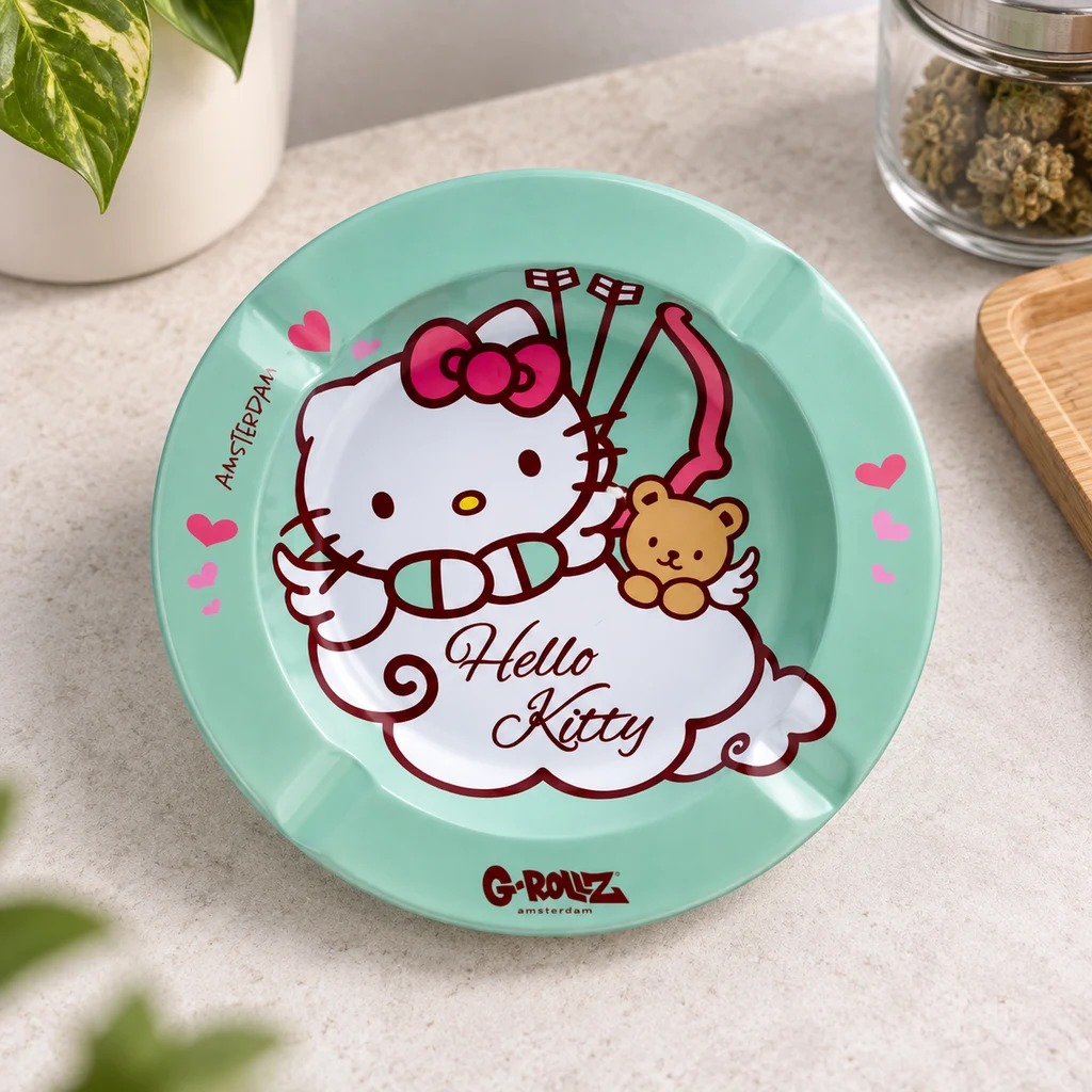 Cenicero verde agua G-Rollz con Hello Kitty caracterizada de Cupido, un osito y corazones rosas, sobre una encimera.