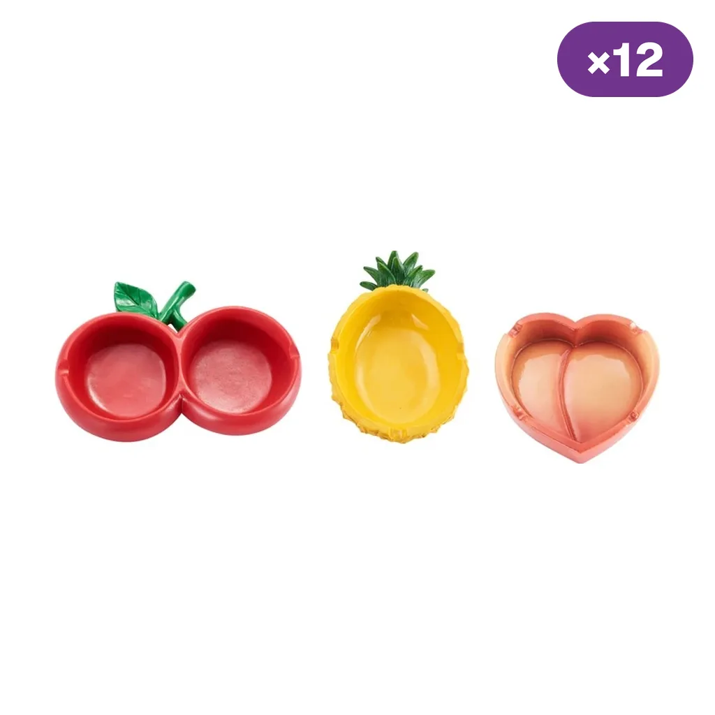 Selección de ceniceros Champ High Food con formas de cerezas rojas, piña amarilla y melocotón rosado, junto a un distintivo ×12.