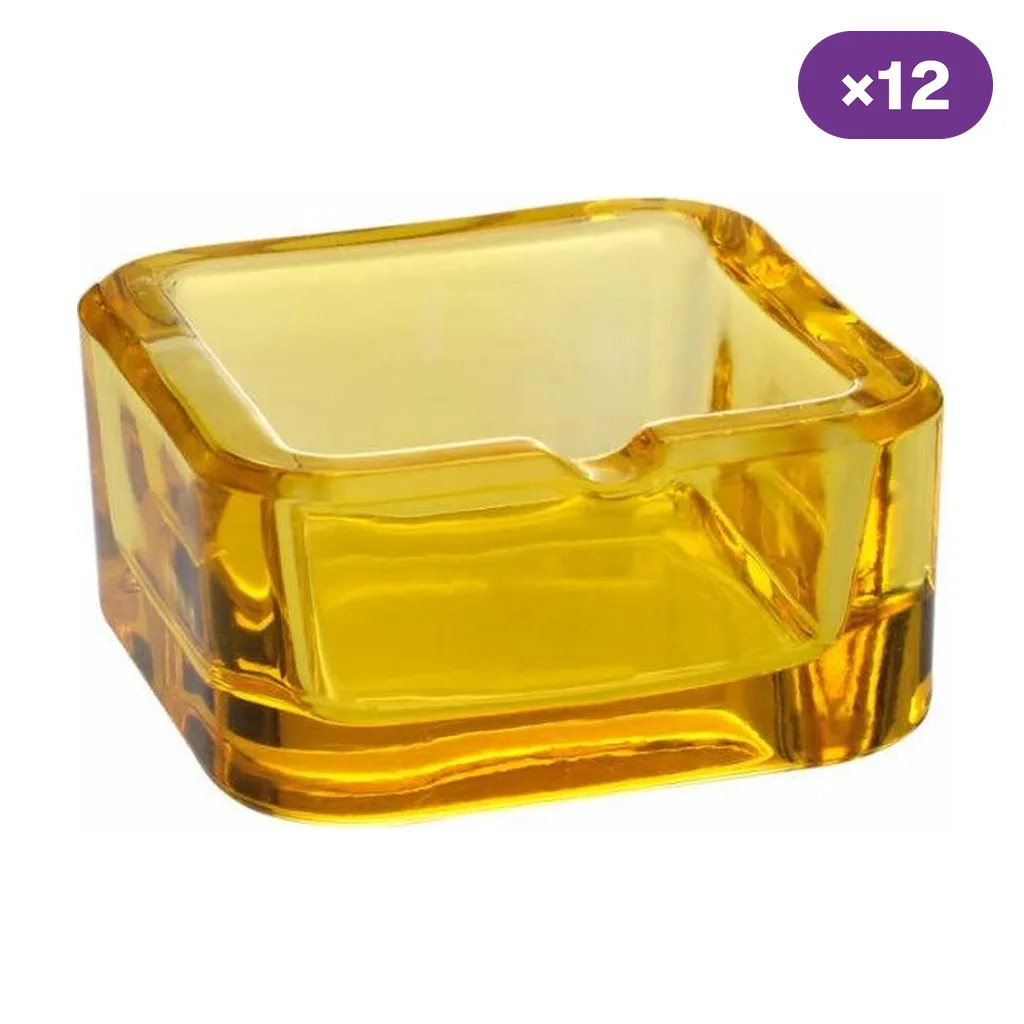 Cenicero cuadrado de cristal amarillo transparente, con paredes gruesas, esquinas redondeadas y una muesca visible en el borde.