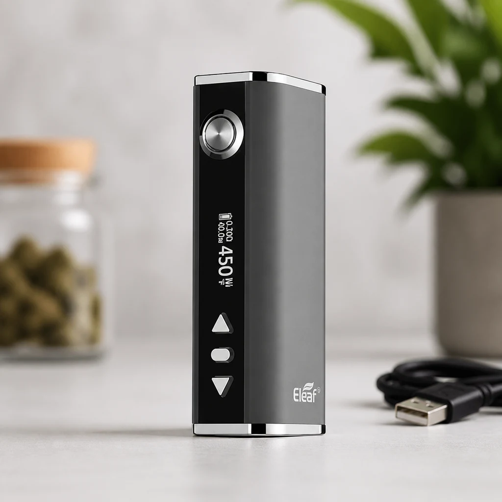 Mod Eleaf gris y negro en posición vertical, con botón circular, pantalla y controles frontales, junto a un cable USB sobre una mesa.
