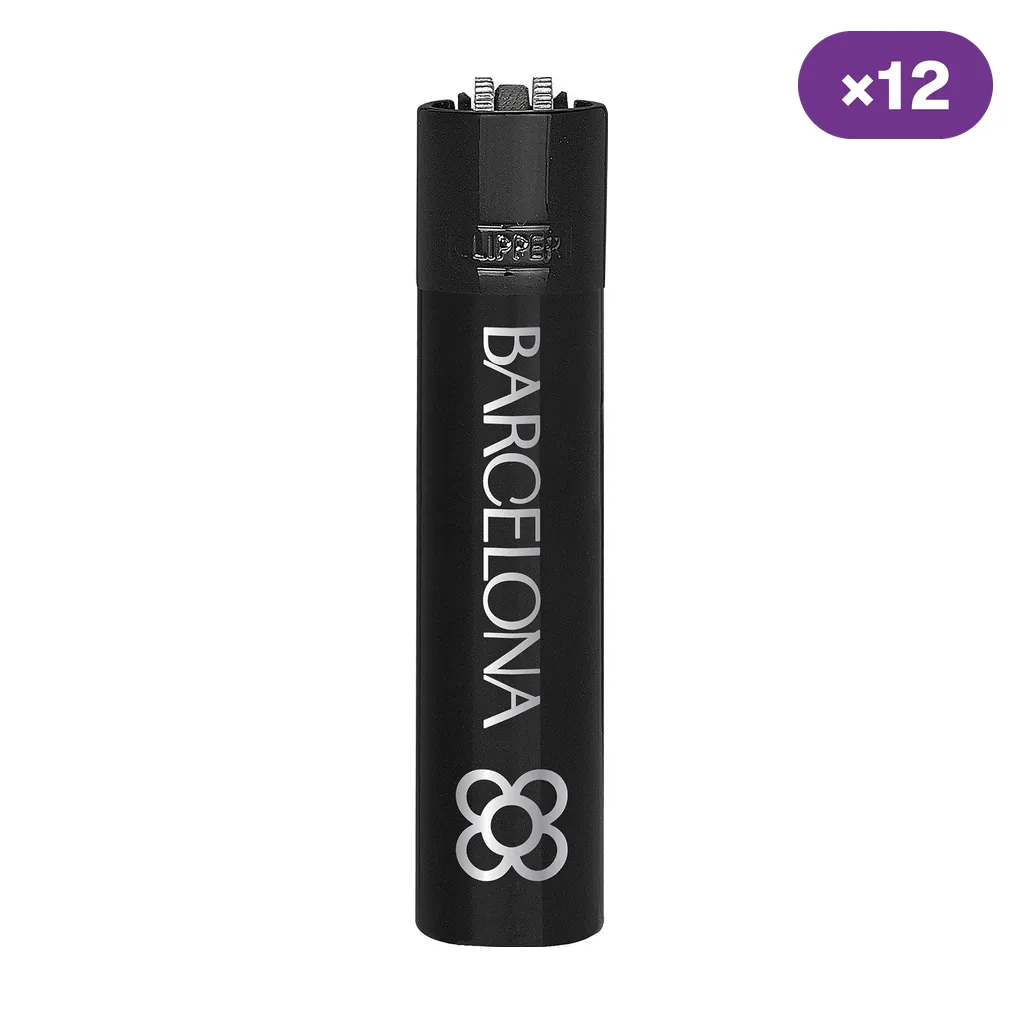 Encendedor Clipper negro con inscripción Barcelona y símbolo floral plateados, junto a un distintivo de 12 unidades.