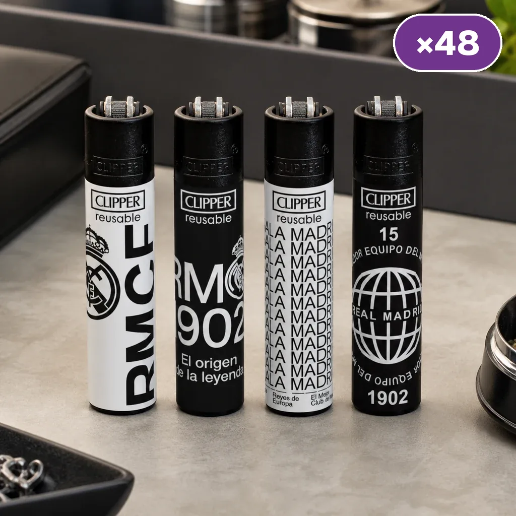 Cuatro diseños de encendedores Clipper del Real Madrid en blanco y negro, alineados sobre una mesa, con distintivo «×48».