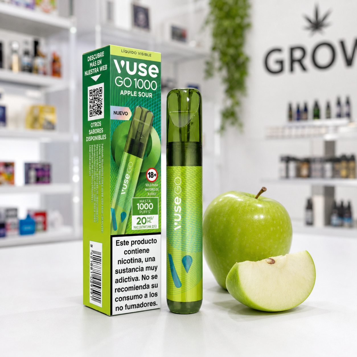 Vaper verde Vuse Go 1000 junto a su caja Apple Sour, con advertencia de nicotina, una manzana verde y un gajo sobre un mostrador.