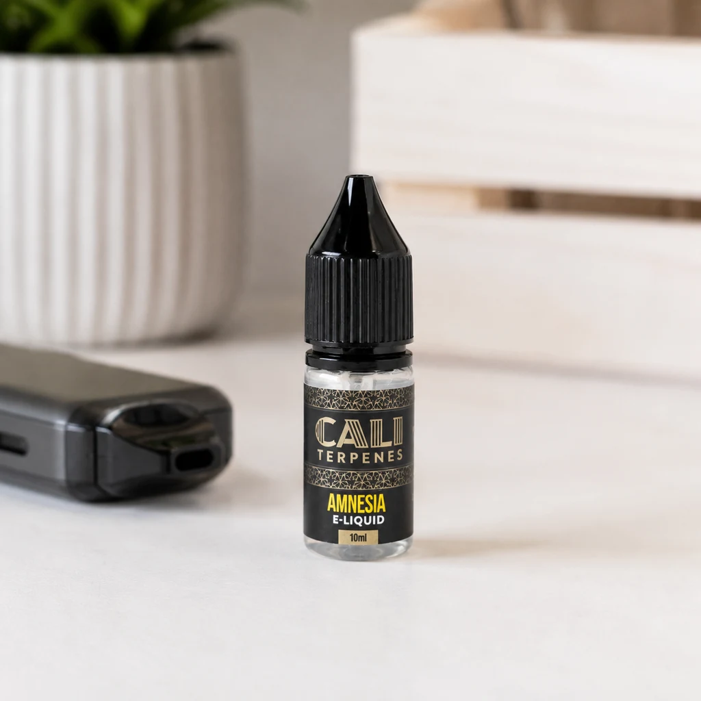 Frasco de E-Liquid Cali Terpenes Amnesia de 10 ml con tapón negro, sobre una mesa junto a un dispositivo de vapeo.