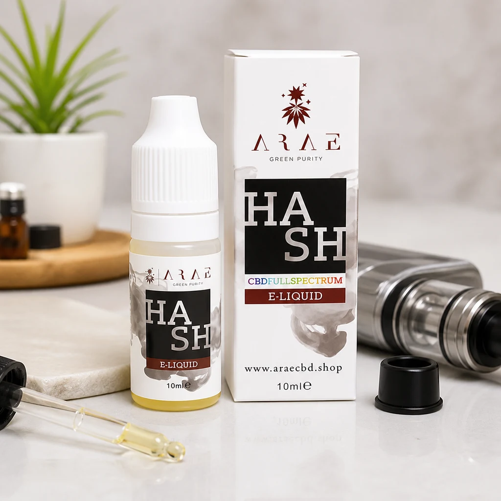 Frasco de ARAE Hash CBD E-Liquid de 10 ml junto a su caja blanca, con un cuentagotas y un dispositivo de vapeo sobre la mesa. Frasco de ARAE Hash CBD E-Liquid de 10 ml junto a su caja blanca, con un cuentagotas y un dispositivo de vapeo sobre la mesa.