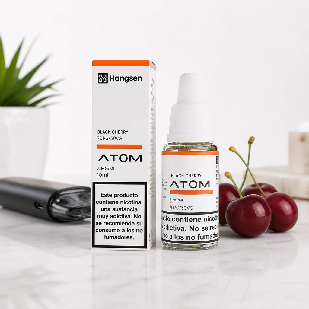 Frasco y caja Hangsen Atom Black Cherry con etiquetas de 3 mg/ml y 10 ml, junto a cerezas y un dispositivo de vapeo.