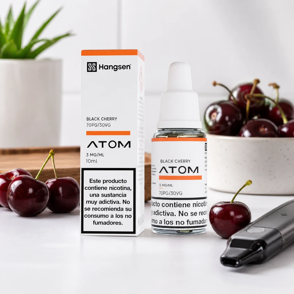 Frasco y caja Hangsen Atom Black Cherry con etiqueta de 3 mg/ml, junto a cerezas y un dispositivo de vapeo.