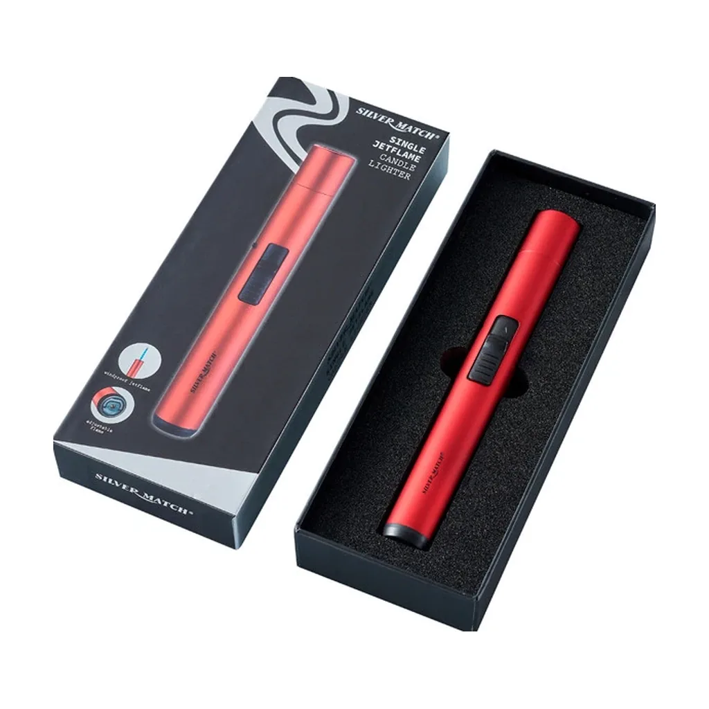 Encendedor rojo Silver Match Jet Flame Vela, alargado y con deslizador negro, en una caja abierta junto a su tapa ilustrada.
