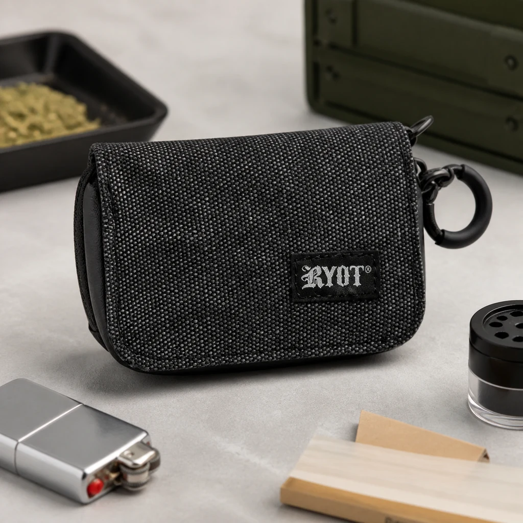 Estuche negro RYOT Krypto-Kit con textura tejida, solapa y enganche lateral, sobre una mesa junto a un encendedor y papel de liar.