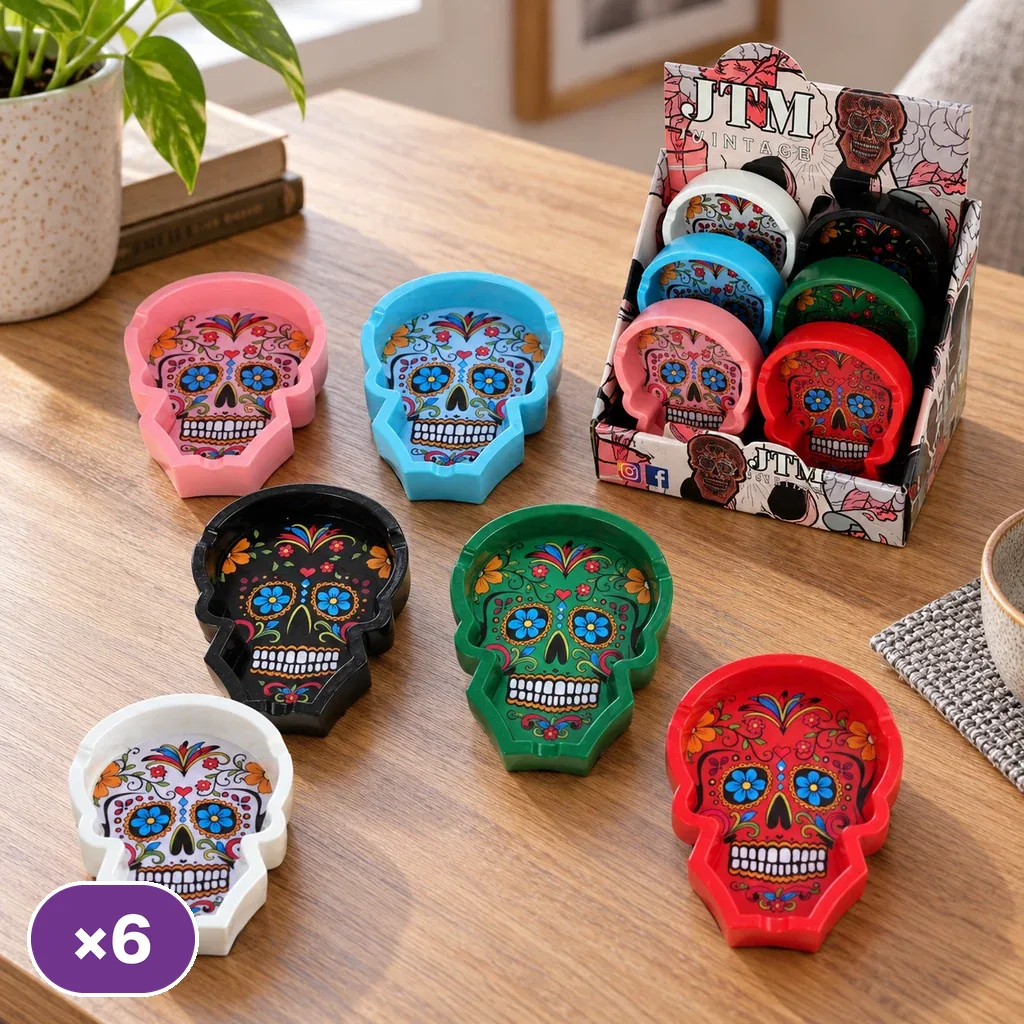 Ceniceros Skull de varios colores con forma de calavera y motivos florales, sobre una mesa de madera junto a un expositor.