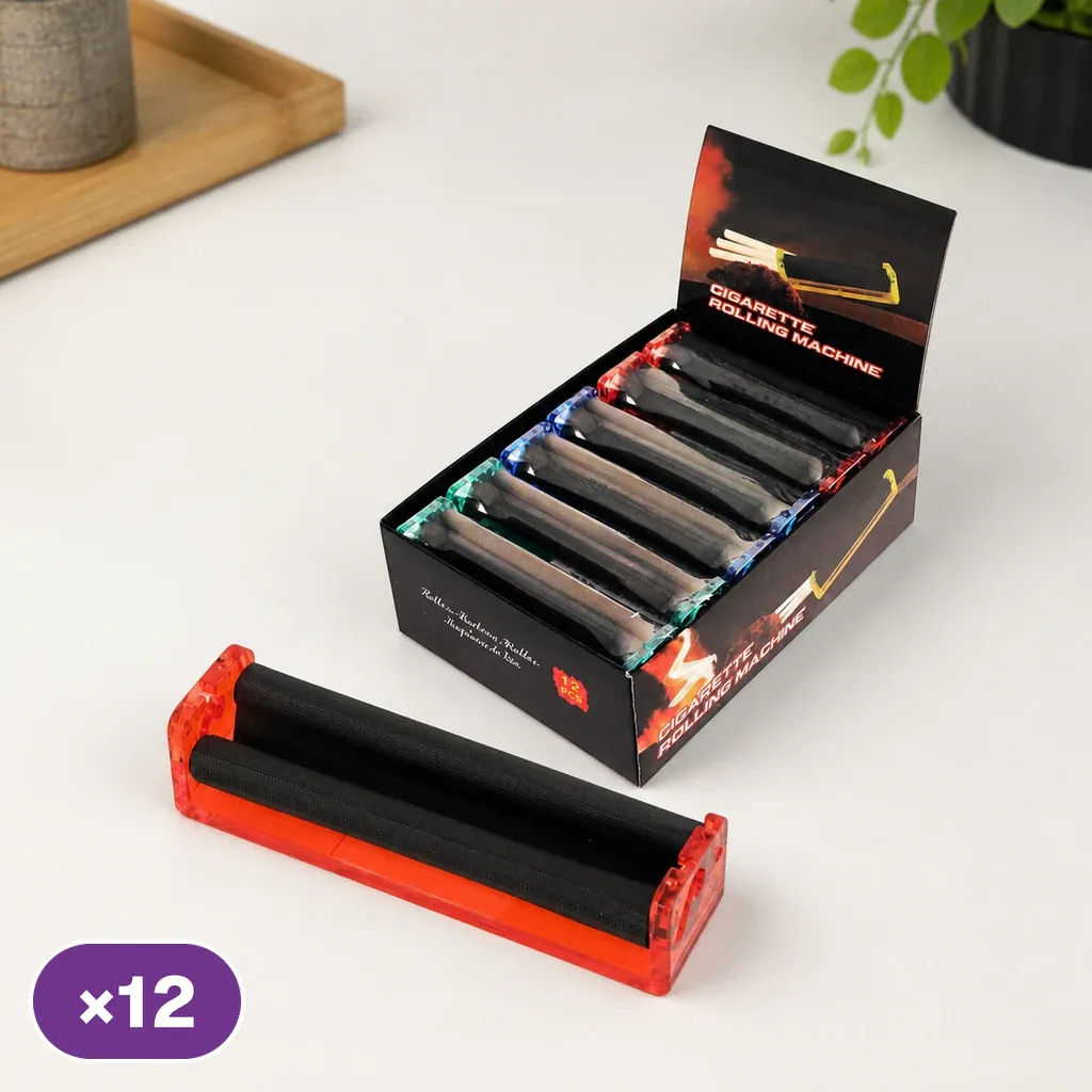 Máquina de liar roja con rodillos negros en primer plano y caja expositora con unidades de distintos colores detrás; distintivo ×12.