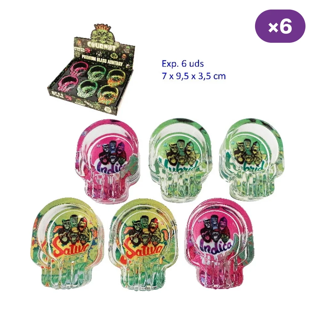 Ceniceros de cristal con forma de calavera, diseños rosas y verdes con textos Sativa, Indica e Hybrid, junto a su expositor.